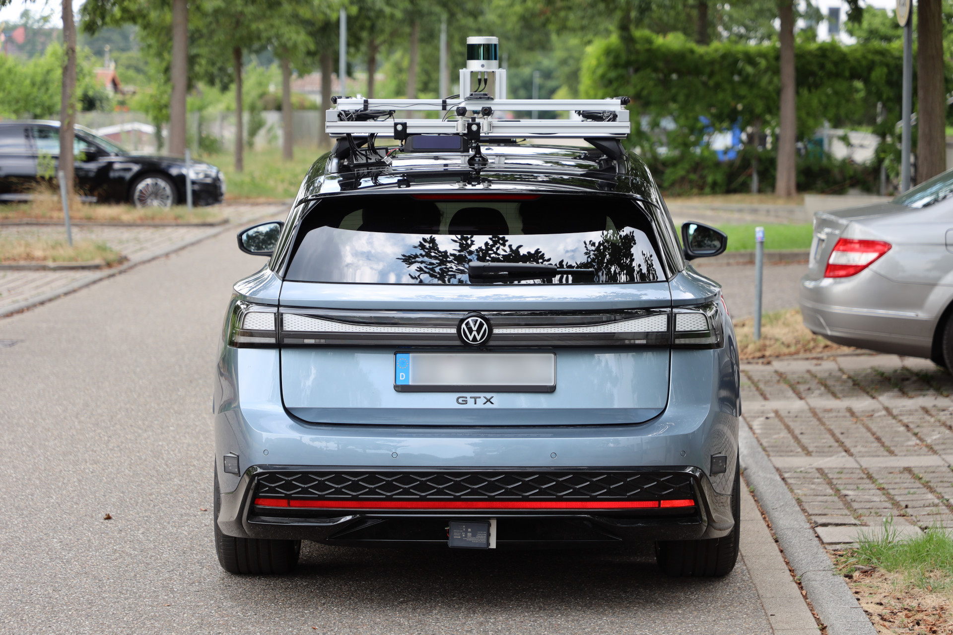 Rear view of the research vehicle showing the roof rack from behind and the radars integrated into the rear bumper.
