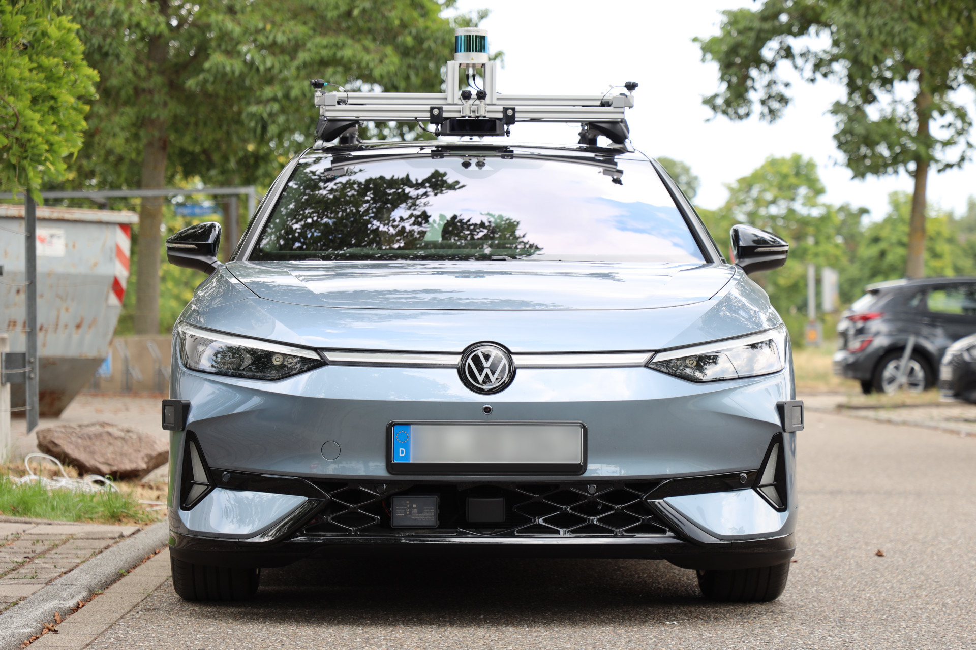 Front view of the research vehicle showing the roof rack, the forward cameras and the radars integrated into the front bumper.